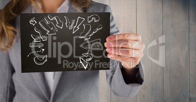 Business woman mid section with black card showing white arrow doodles against wood panel