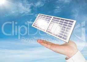 Digital image of solar panel on hand against sky