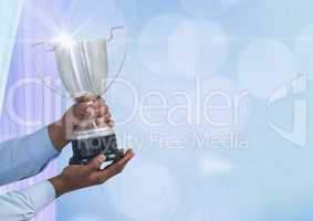 Hands holding trophy against abstract background