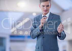 Businessman holding glass screen in large bright space