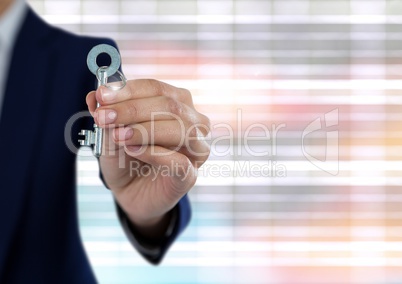 Hand holding key with bright ridged blurry background