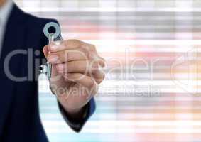 Hand holding key with bright ridged blurry background