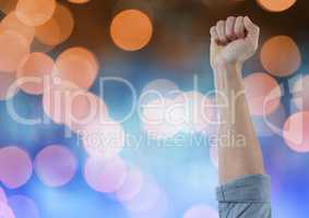 Hand arm celebrating with fist and sparkling light bokeh background