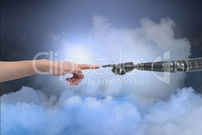 Human and robot touching their fingers in cloudy background