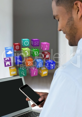 Businessman holding phone with apps icons in room