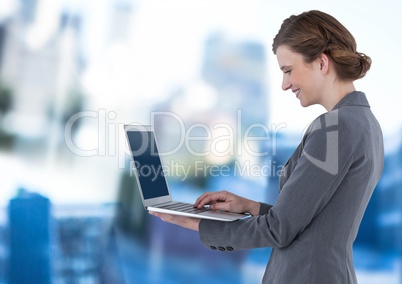 Businesswoman holding laptop in blue motion public space