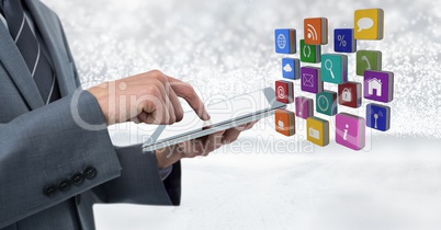 Businessman holding tablet with apps icons with bright sparkling star spangled background