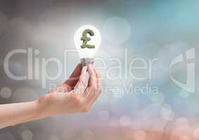 Hands holding lightbulb with money symbol with sparkling light bokeh background