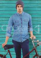 hipster with bike in front of  light blue wood background