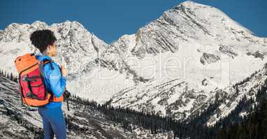 Side view of hipster carrying backpack with camera and looking at mountains
