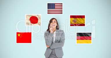 Thoughtful businesswoman standing by flags against blue background