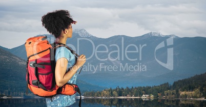 Side view of hiker standing against lake and mountains