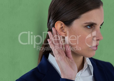 Businesswoman listening gossip while standing against green background