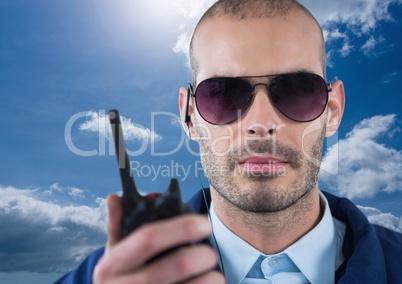 Security guard holding walkie talkie during sunny day