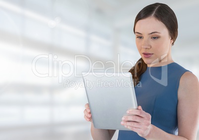 Businesswoman holding tablet in bright space hall