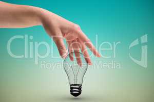 Hand holding bulb light in green background