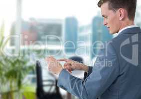 Businessman holding glass tablet in bright office
