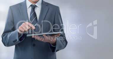 Businessman holding tablet with grey lights background