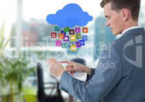 Businessman holding glass tablet with apps icons in bright office