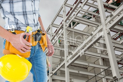 architect is wearing tool belt against construction background