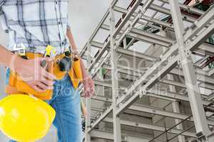 architect is wearing tool belt against construction background