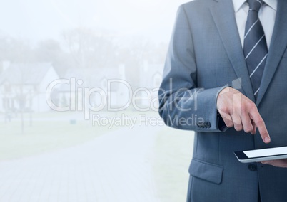 Businessman holding tablet in bright housing estate