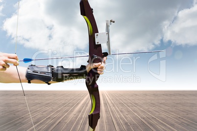 Part of archery player with desert and blue sky background