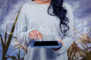 Mid section of woman using digital tablet against field