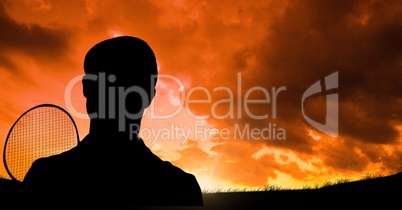 Silhouette man with badminton bat against cloudy sky during sunset