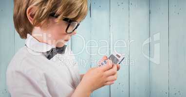 Boy with calculator against blue wood panel