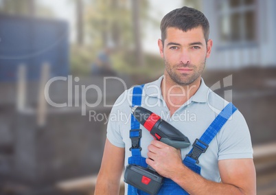 Carpenter with drill on building site