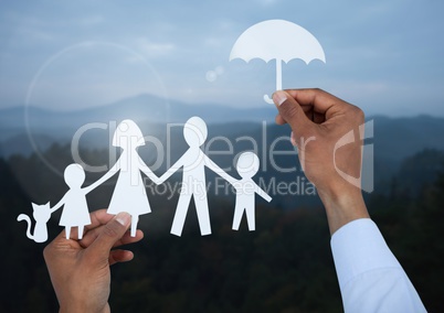 Cut outs family under protective umbrella with landscape