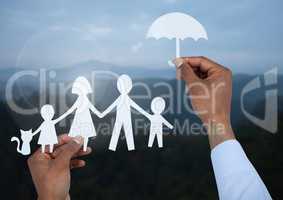 Cut outs family under protective umbrella with landscape