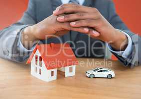 Models hands protective over house and car