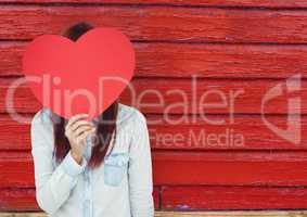hipster woman  with the face covered with a heart.  red wood background