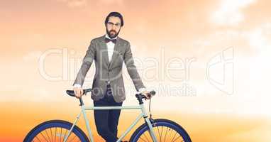 Reflecting hipster man with a bike in front of  orange background