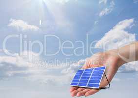 Digital image of solar panel on hand against sky during sunny day