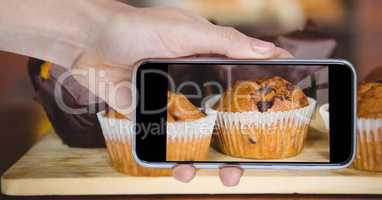 Hand photographing muffins through smart phone