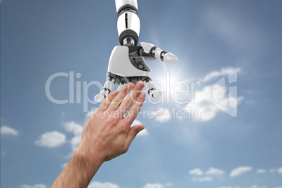 Human and robot touching their hands in blue background