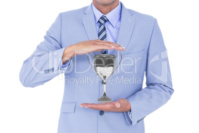 Business man holding a trophy in his hands against white background