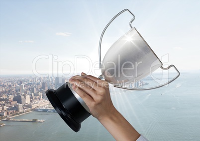 business hand with trophy in front of the city