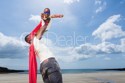 Father holding his son dress like a superhero