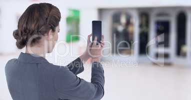 Businesswoman holding mobile phone in shopping mall