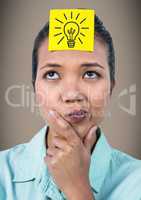 Woman thinking with yellow sticky note on head showing grey lightbulb graphic against brown backgrou