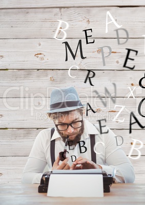 Hipster man with a pipe reflecting on his typewriter in front of wood wall
