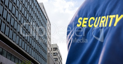 Security person with blue jacket  in front of a big building