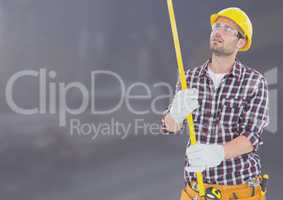 Construction Worker with measuring tape in front of construction site