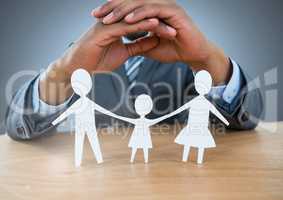 Cut out family under protective hands