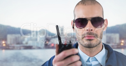 Security guard with walkie talkie against blurry skyline