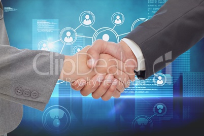 Businessman shaking their hands with a blue digital background